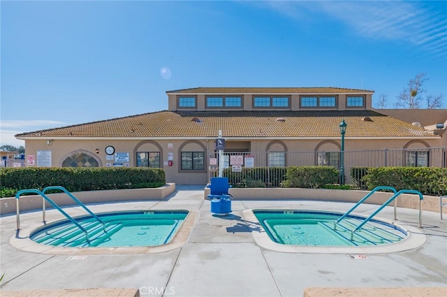 view of pool featuring fence and a hot tub