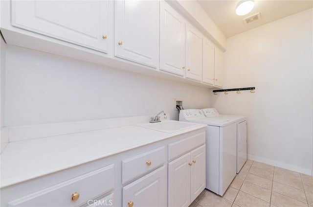 laundry area with washing machine and clothes dryer, visible vents, light tile patterned floors, cabinet space, and a sink