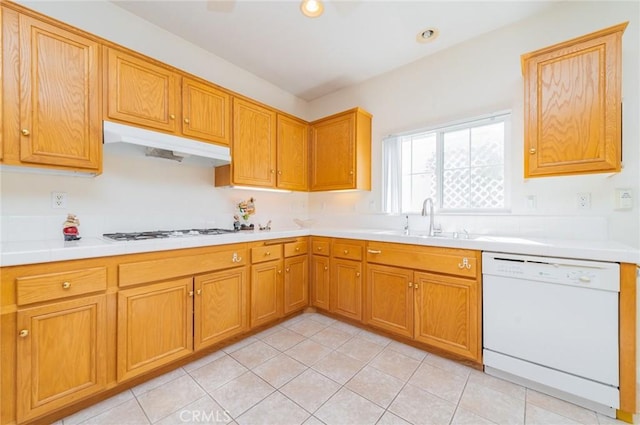 kitchen featuring white appliances, under cabinet range hood, light countertops, and a sink