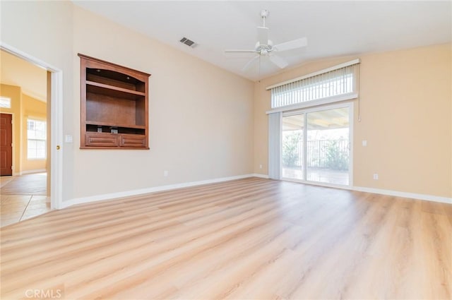 spare room with a healthy amount of sunlight, visible vents, light wood finished floors, and baseboards