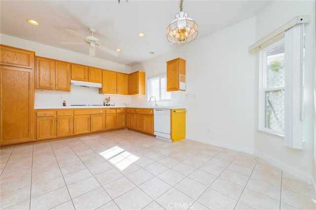 kitchen with under cabinet range hood, light countertops, brown cabinets, dishwasher, and decorative light fixtures