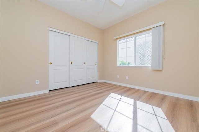 unfurnished bedroom with a ceiling fan, light wood-style floors, baseboards, and a closet