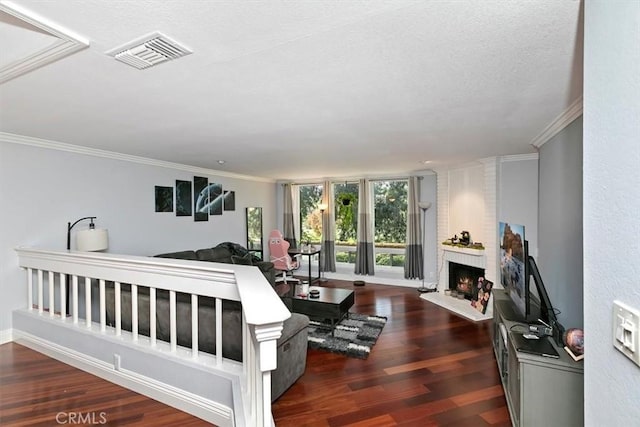 interior space with dark wood-type flooring, visible vents, a fireplace, and ornamental molding