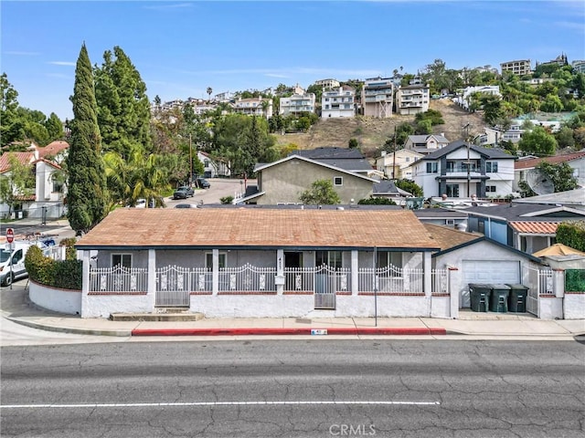 view of front of property featuring a garage, a fenced front yard, and a residential view