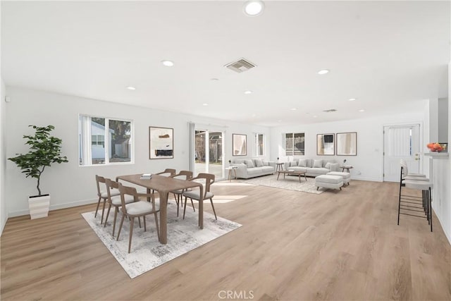 dining room with light wood finished floors, baseboards, visible vents, and recessed lighting