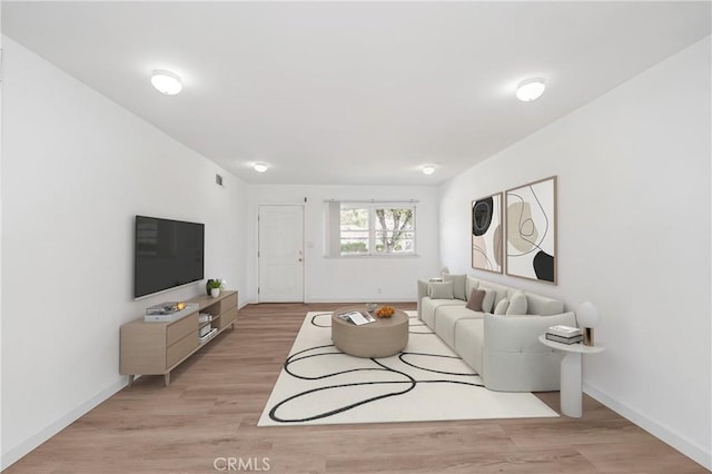 living area featuring light wood-type flooring, visible vents, and baseboards