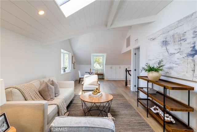 living area with visible vents, lofted ceiling with skylight, light wood-style flooring, and wooden ceiling