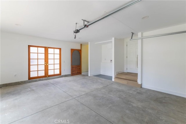 garage featuring french doors and baseboards