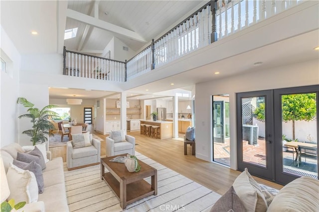 living room with recessed lighting, french doors, vaulted ceiling with beams, and light wood-style floors