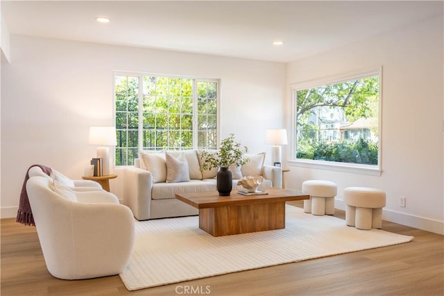 living room with a wealth of natural light, recessed lighting, light wood-type flooring, and baseboards