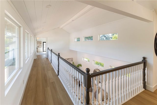 hall featuring an upstairs landing, lofted ceiling with beams, wood finished floors, wooden ceiling, and baseboards