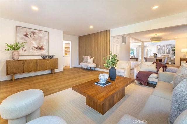 living area featuring visible vents, recessed lighting, baseboards, and wood finished floors