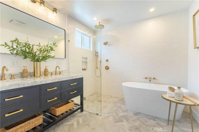 bathroom featuring a sink, a freestanding tub, double vanity, and a walk in shower