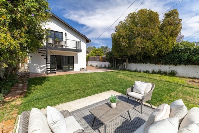 exterior space featuring a patio, fence, a yard, outdoor lounge area, and stairs