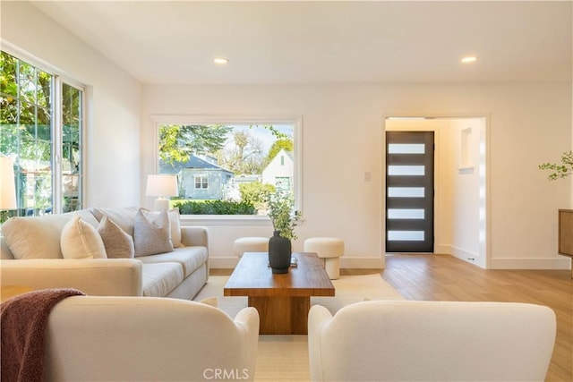 living room with recessed lighting, baseboards, and light wood finished floors