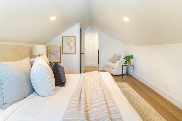 bedroom featuring lofted ceiling, recessed lighting, wood finished floors, and baseboards