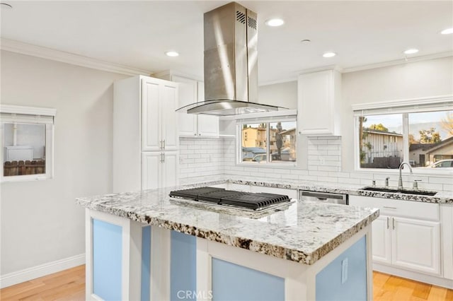 kitchen with white cabinetry, island exhaust hood, a kitchen island, and a sink