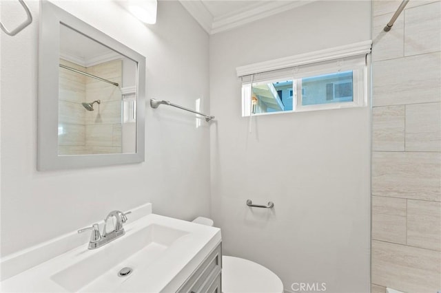 full bath featuring toilet, tiled shower, crown molding, and vanity