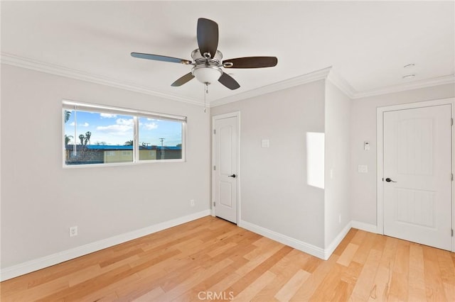 empty room featuring baseboards, wood finished floors, a ceiling fan, and crown molding