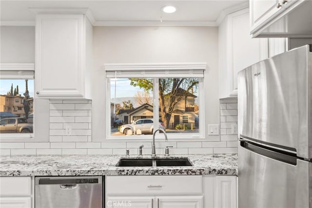 kitchen with white cabinetry, appliances with stainless steel finishes, light stone counters, and a sink