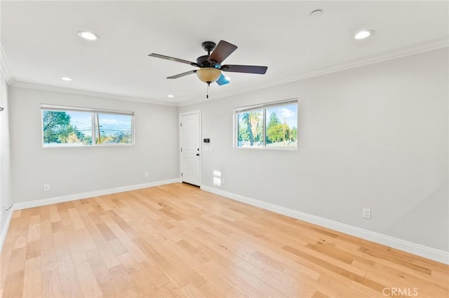 empty room featuring light wood-style floors, baseboards, and ornamental molding