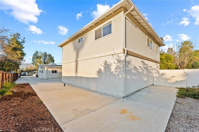 view of home's exterior with a patio and fence