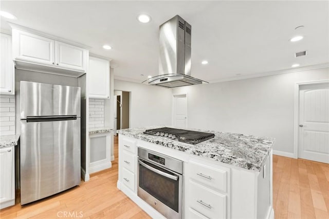 kitchen with visible vents, island range hood, decorative backsplash, stainless steel appliances, and white cabinetry