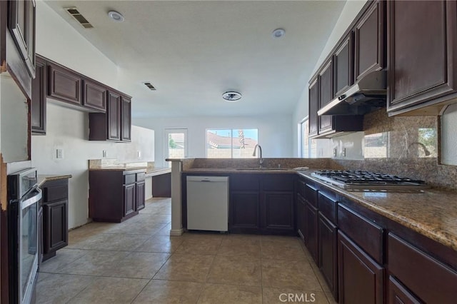 kitchen featuring visible vents, appliances with stainless steel finishes, a sink, a peninsula, and under cabinet range hood