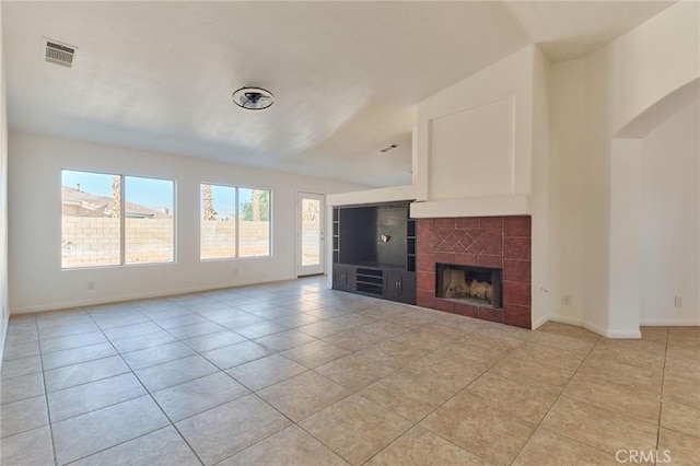 unfurnished living room with a tile fireplace, visible vents, baseboards, and light tile patterned flooring