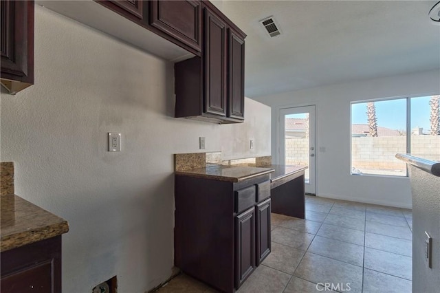 kitchen featuring visible vents, dark brown cabinetry, baseboards, and light tile patterned floors