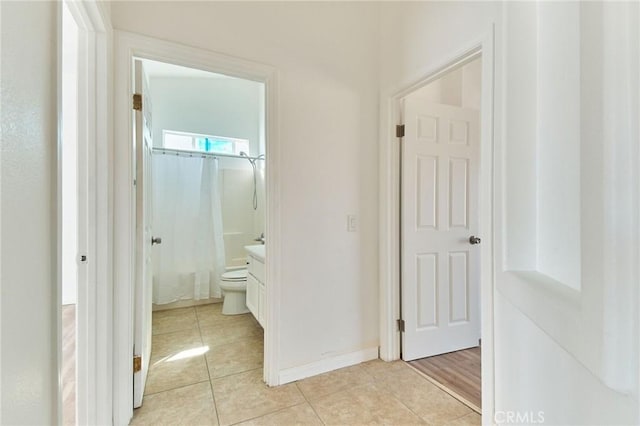 hall with light tile patterned floors and baseboards