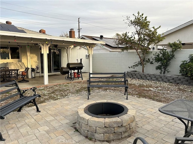 view of patio featuring a fenced backyard, a fire pit, and grilling area