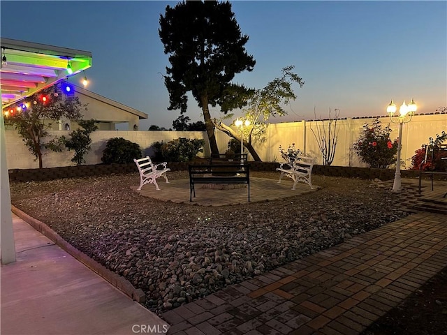 yard at dusk featuring a patio area and a fenced backyard