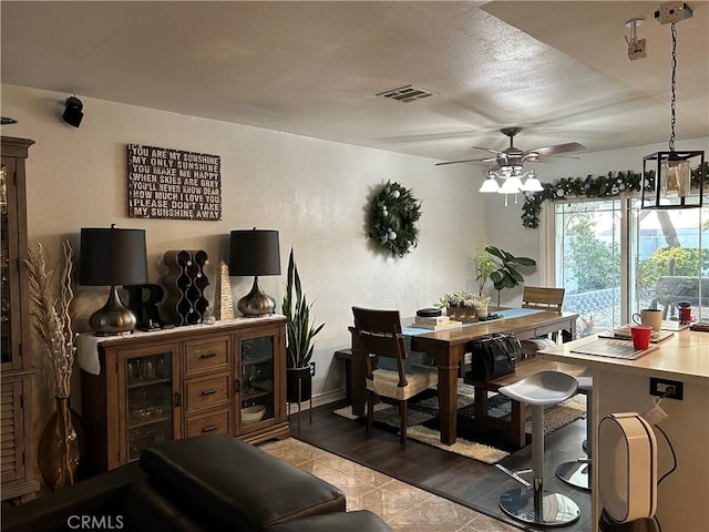 interior space featuring a ceiling fan, visible vents, and light tile patterned floors