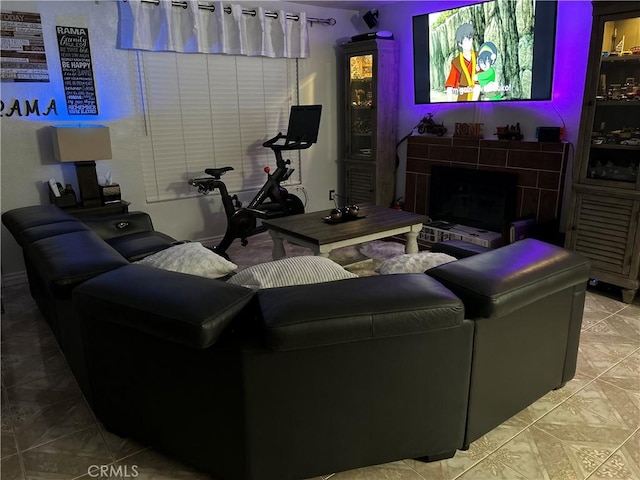 living area with a fireplace and light tile patterned flooring