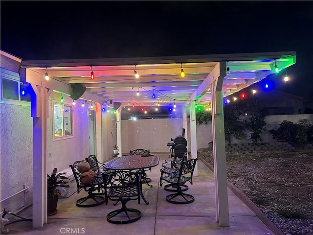 patio at night featuring a pergola