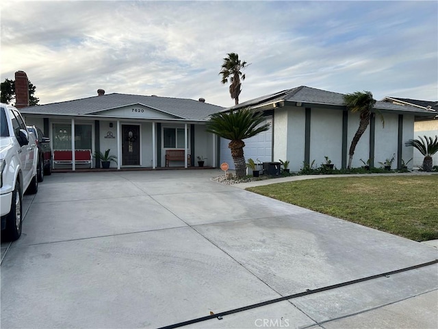 view of front facade with driveway, a front lawn, and stucco siding