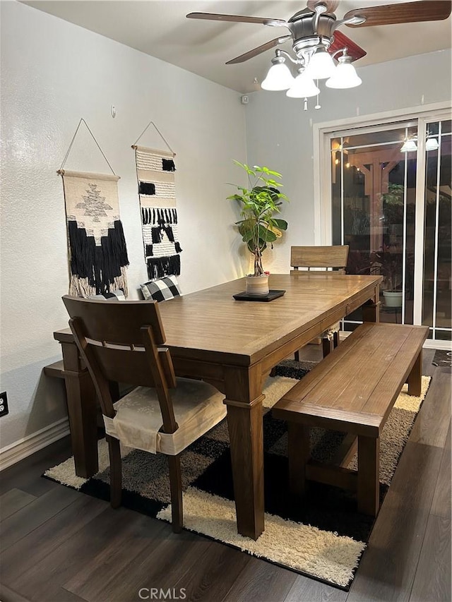 dining area with ceiling fan, dark wood-style flooring, and baseboards