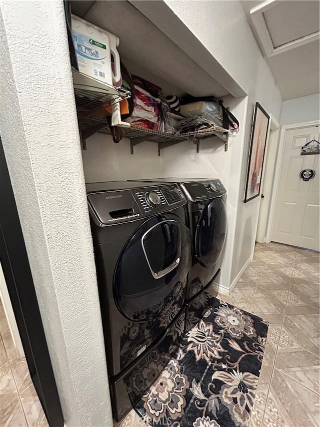 clothes washing area featuring laundry area, separate washer and dryer, attic access, and baseboards