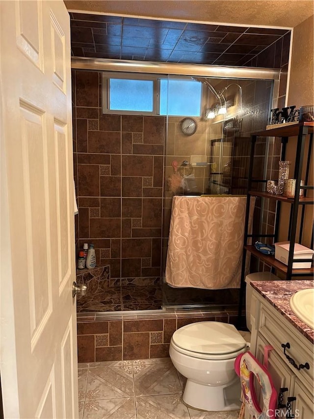 full bathroom featuring toilet, a stall shower, and vanity