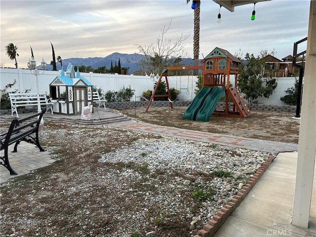 communal playground with a fenced backyard and a mountain view