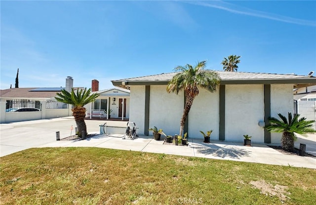 ranch-style house with a patio, a front lawn, stucco siding, and fence