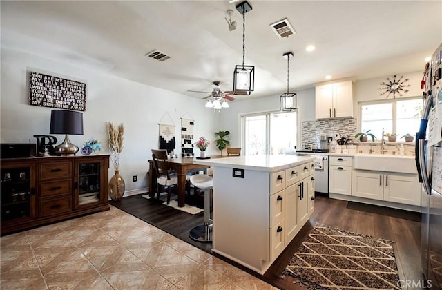 kitchen featuring light countertops, plenty of natural light, visible vents, and stainless steel dishwasher