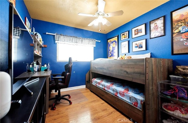 bedroom with baseboards, a ceiling fan, and wood finished floors