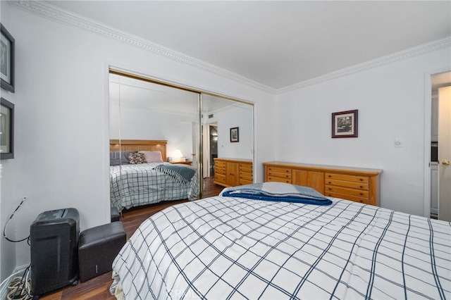 bedroom with ornamental molding, dark wood-type flooring, and a closet