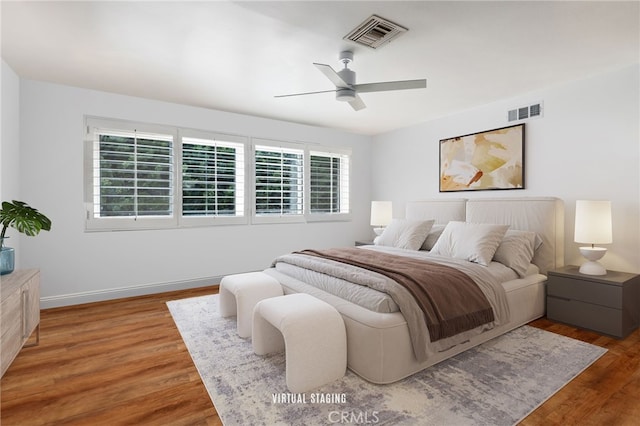 bedroom featuring visible vents, ceiling fan, baseboards, and wood finished floors