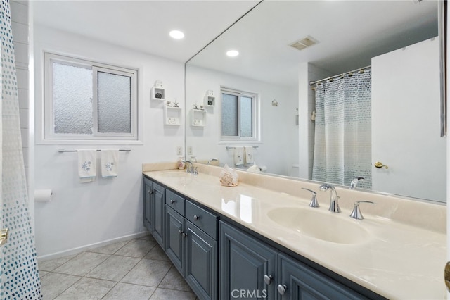 bathroom featuring double vanity, visible vents, a sink, and tile patterned floors