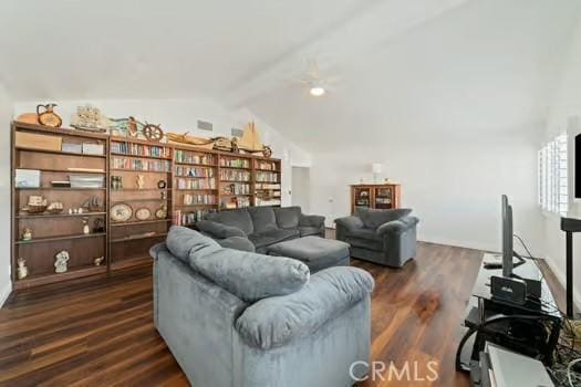 sitting room with dark wood finished floors and lofted ceiling with beams