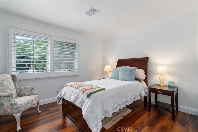 bedroom with dark wood-style floors, visible vents, and baseboards