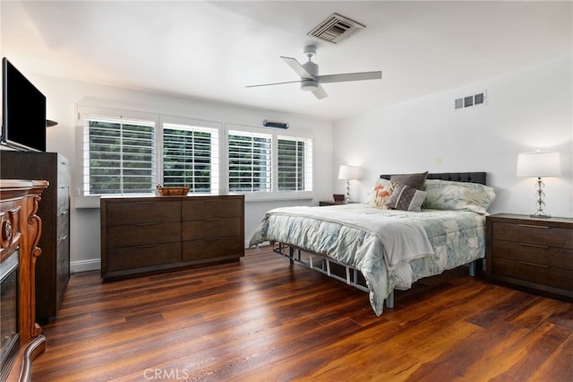 bedroom with dark wood-style floors, ceiling fan, and visible vents